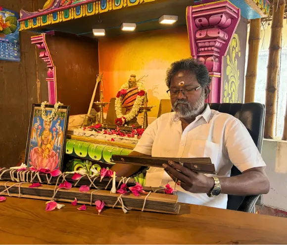 Authentic Nadi astrologer reading ancient palm leaf manuscripts